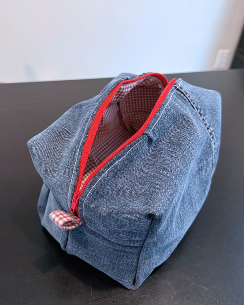 Blue pouch with a red zipper on a gray surface